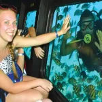 Manolo Tours tourists watching colorful fish through Sea Scope windows.