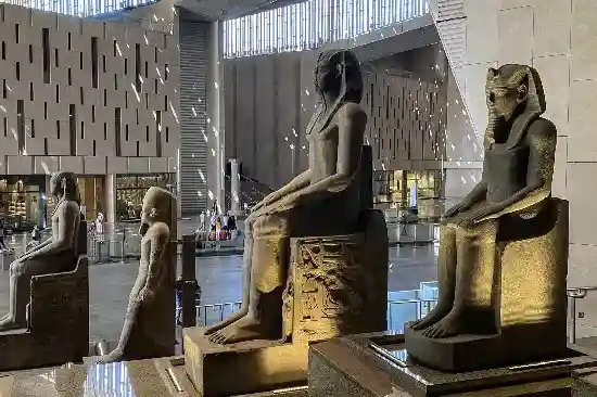 Modern interior and ancient artifacts of the Grand Egyptian Museum in Cairo.