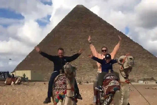 Tourists enjoying the pyramids panorama on Cairo day trip.