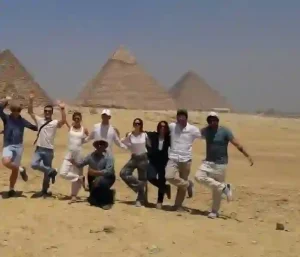 Small group of happy tourists at the Great Pyramid of Khufu.
