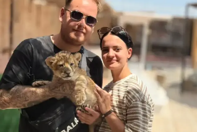 Couple holding a baby lion together on a safari trip in Hurghada